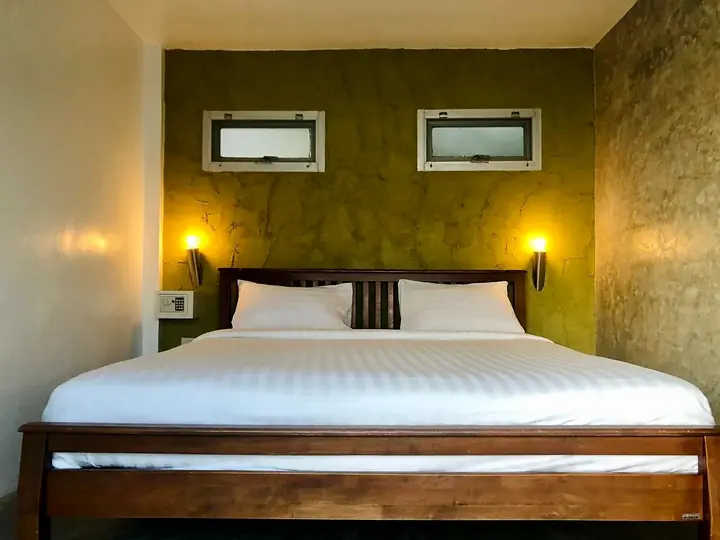 Tweepersoonsbed met wit beddengoed in een Front Sea View-bungalow