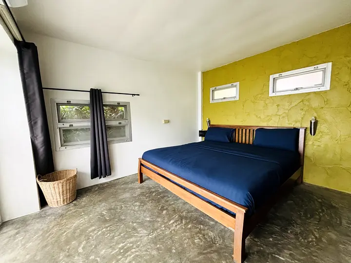 Front Sea View-bungalow: het bed, de gele muur en de ramen, gezien vanuit de hoek