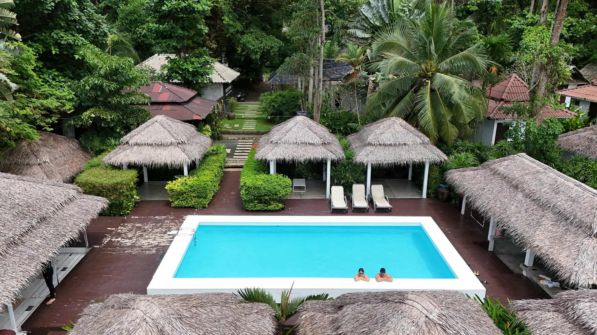 Aerial view over the pool to the salas and the garden bungalows in the trees