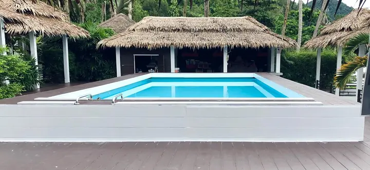 Zwembad met de rieten cabana's erachter