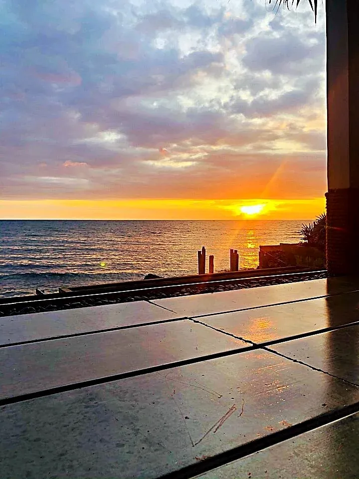 The sun setting over the sea seen from the covered deck